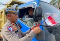 Foto : Polres Melawi membagikan bendera kepada masyarakat pengguna jalan di Tugu Juang II Nanga Pinoh