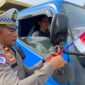 Foto : Polres Melawi membagikan bendera kepada masyarakat pengguna jalan di Tugu Juang II Nanga Pinoh