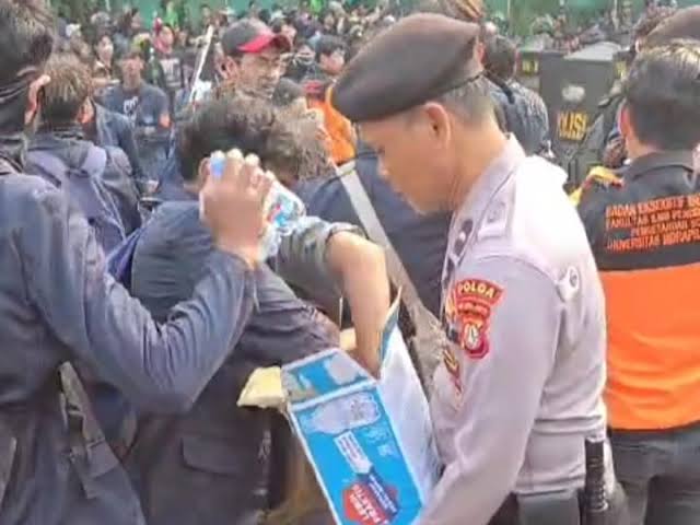 Foto : Polisi bagikan air kepada demonstran di Jalan Gerbang Pemuda