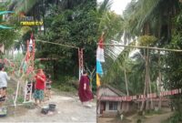 Foto : Kegiatan gotong royong mengecat bambu dengan warna merah putih serta memasang bendera di sepanjang jalan