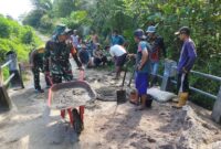 Foto :  Babinsa Koramil 07/Jgb Kopda M Nuril bersama warga melaksanakan pengecoran jalan di Dsn. Saparan Ds. Kumba Kec. Jagoi Babang Kab. Bengkayang