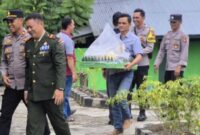 Foto : Kapolsek Sepauk IPTU Abdul Hadi, membawa nasi tumpeng untuk selanjutnya diberikan kepada Danramil 1205-06/Sepauk Peltu Yohanes beserta jajarannya