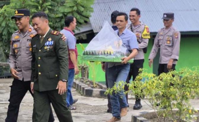 Foto : Kapolsek Sepauk IPTU Abdul Hadi, membawa nasi tumpeng untuk selanjutnya diberikan kepada Danramil 1205-06/Sepauk Peltu Yohanes beserta jajarannya