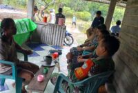 Foto : Anggota Satgas menyempatkan waktu untuk bersilaturahmi dengan warga desa