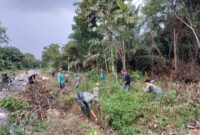 Foto : Satgas bersama warga bergotong royong membersihkan area di sekitar jalan yang telah dilakukan penimbunan